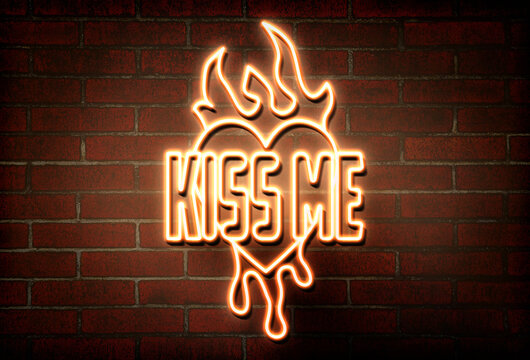 Glowing neon sign with words Kiss Me, heart and flames on brick wall