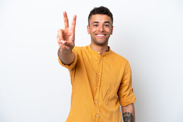 Young caucasian Brazilian man isolated on white background smiling and showing victory sign