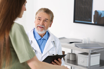 Professional orthopedist examining patient in clinic, space for text - Powered by Adobe