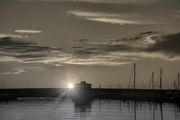 Alba di sole che sorge da dietro il porto 