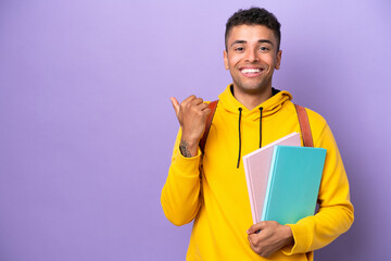 Young student Brazilian man isolated on purple background pointing to the side to present a product