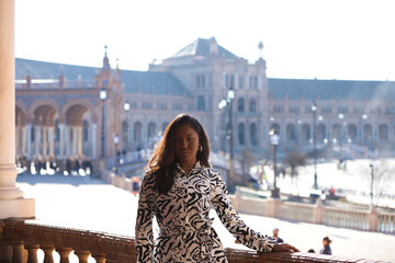 beautiful and young latin black woman is in the most important and biggest square of seville. The woman enjoys her holidays in spain and its climate. Holiday and travel concept.