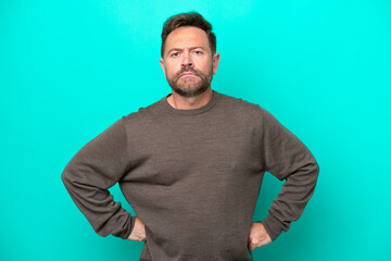 Middle age caucasian man isolated on blue background angry