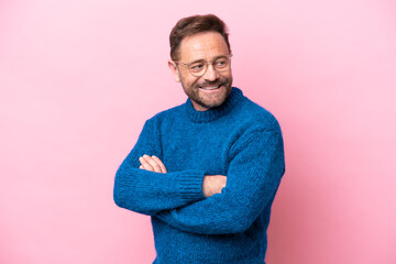 Middle age caucasian man isolated on pink background looking to the side and smiling