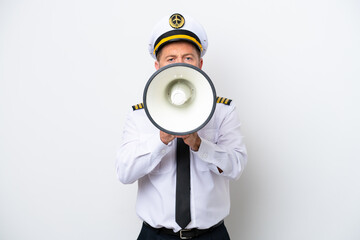 Airplane middle age pilot isolated on white background shouting through a megaphone