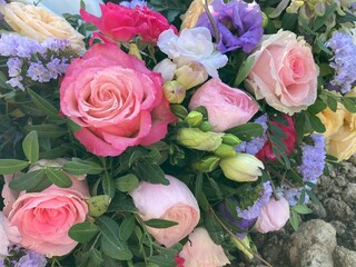 Blumen in Pastellfarben in einem Trauerkranz nach Beerdigung auf dem Friedhof