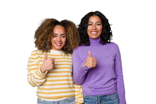 Two female friends isolated in studio smiling and raising thumb up