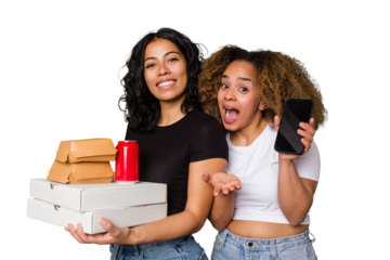 Two young women, one Latina and one with Afro hair, laugh as they hold pizzas and burgers from a recent delivery. 