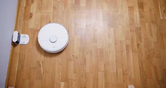 Robot vacuum cleaner performs automatic cleaning of the house at a certain time. Smart home concept. Copy space