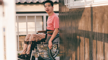 Fototapeta na wymiar Young man with disability training move wheelchair by himself in the ramp of home or hospital,school,nursery, Self-help development in daily life, Positive photography and Good health concept.