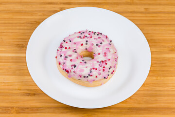 Ring doughnut filled with strawberry cream covered with sugar icing