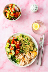 Healthy lunches, quinoa with green peas, with baked red fish salmon and fresh salad of tomato, cucumber and greens, top view