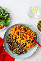 Healthy lunches, wild rice with carrot and tomato gravy, broccoli and onion, fresh mixed salad with pumpkin seeds, water with lemon, top view