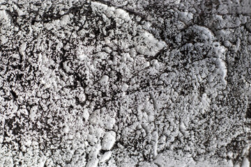 White textured putty background with a black pattern. Macro photo of the wall. Copy space
