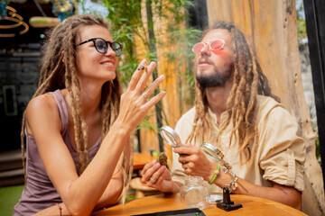 Hippie style couple smoking cigarettes with medical marijuana