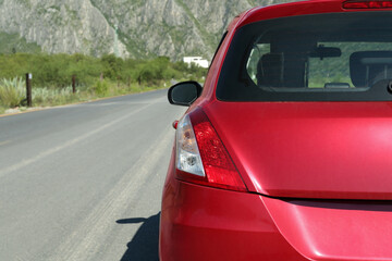 Beautiful view of mountains and car on asphalt highway outdoors, closeup. Road trip