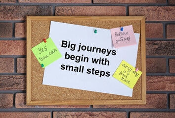 Corkboard with motivational quotes on brick wall
