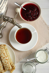 Vintage samovar, cup of hot drink and snacks served on white wooden table, flat lay. Traditional Russian tea ceremony
