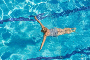 Aerial view of a woman swimming in the pool view from above