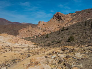 view of colorful volcanic scenic arid landscape of national park El Teide with lava rocks, mountains and vegetation at hiking trail to peak Alto de Guajara. Tenerife, Canary Islands, Spain.