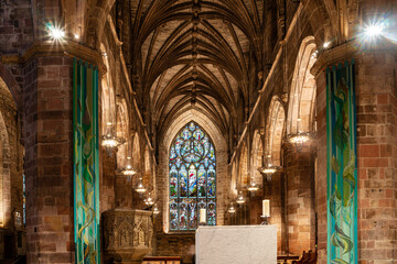 Inside St Giles' Cathedral, stone church with a stone wall and a stone table, stained glass window in a church, stone church with a stained glass window,