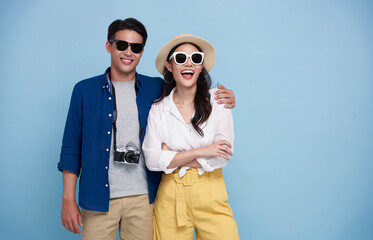 Excited Asian couple tourist dressed in summer clothes to travel on holidays isolated on blue background. - obrazy, fototapety, plakaty