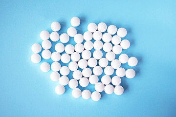White round tablets, supplements on a blue background. Magnesium vitamins