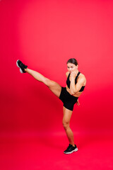 Cool female fighter in boxing bandages trains in studio. Mixed martial arts.