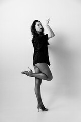 Passionate latina dancer in the studio is dancing in small black dress