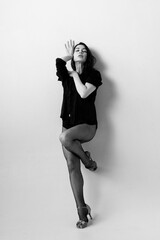 Passionate latina dancer in the studio is dancing in small black dress