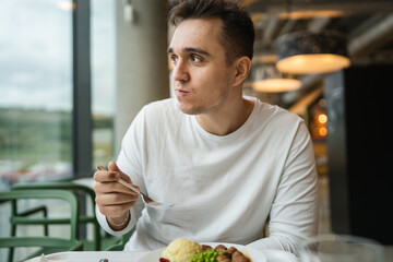 One man young adult caucasian male sitting at restaurant eat