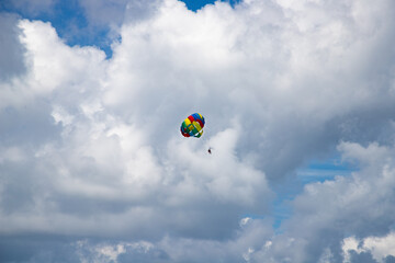 parasailing against blue sky rainbow colors