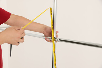 Worker measuring metal pipes for installation, closeup