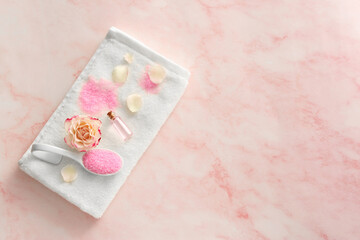 Fototapeta na wymiar Aromatic sea salt, beautiful flower and petals on pink marble table, flat lay. Space for text