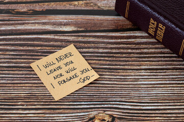 I will never leave you nor will I forsake you-God, handwritten verse on note with holy bible on...