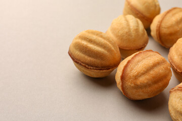 Homemade walnut shaped cookies with condensed milk on light grey background, closeup. Space for text
