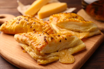 Fresh delicious puff pastry with cheese on wooden table, closeup