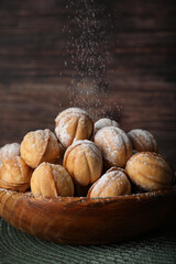 Bowl of delicious nut shaped cookies on wooden table