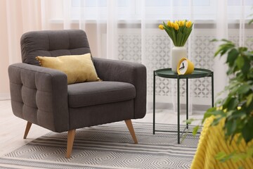 Spring atmosphere. Stylish living room interior with comfortable furniture and bouquet of beautiful yellow tulips