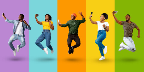 Smiling emotional young black people in casual jumping, make selfie and enjoy win