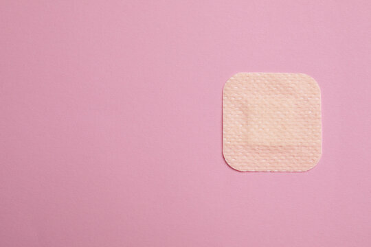 Contraceptive patch on pink background, top view. Space for text