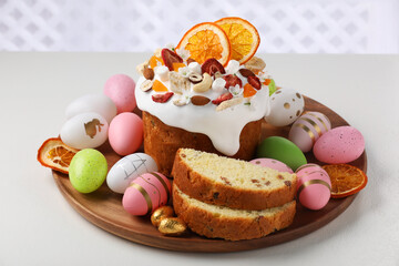 Traditional Easter cake with dried fruits and decorated eggs on white table