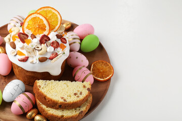 Fototapeta na wymiar Traditional Easter cake with dried fruits and painted eggs on white table, space for text