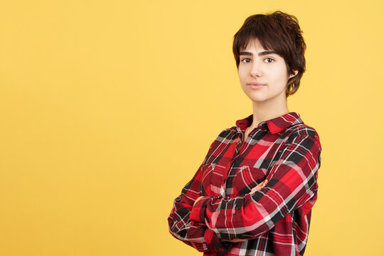 Serious androgynous person standing with arms crossed