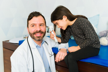 Funny pediatrician playing with a kid patient