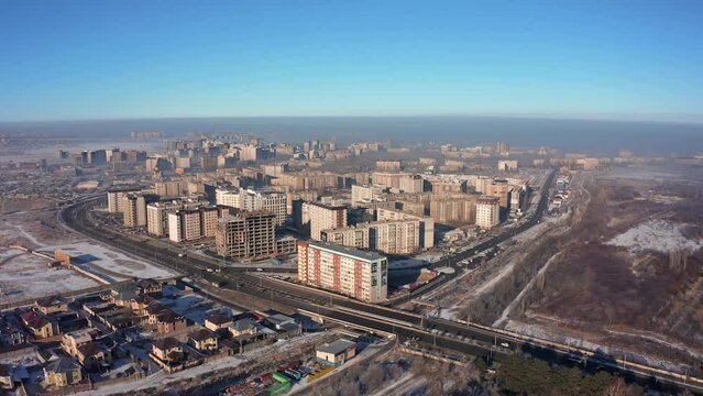 Flying forward directly over the houses of the suburb of the most polluted city in the world Bishkek against the backdrop of a city covered in smog and smoke, the worst ecology