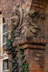 Copenhagen, Denmark Detail of a brick building and a small cherub with ivy.