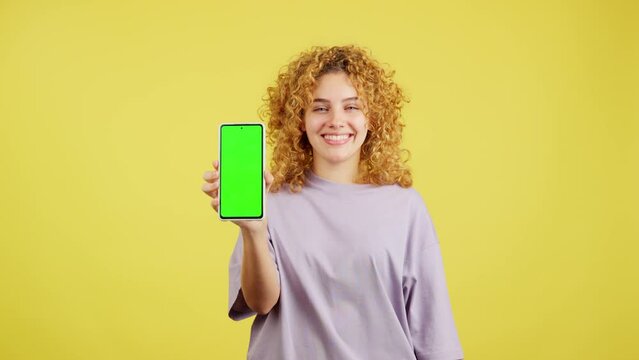 Smiley woman holding a mobile with a chroma screen