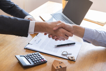 Close up hand of asian young male new landlord, tenant or rental handshake with home, apartment agent or realtor man after bank approved mortgage, loan signed purchase contract. Property of financial.