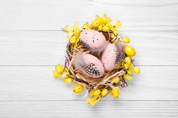 Festively decorated Easter eggs on white wooden table, top view. Space for text
